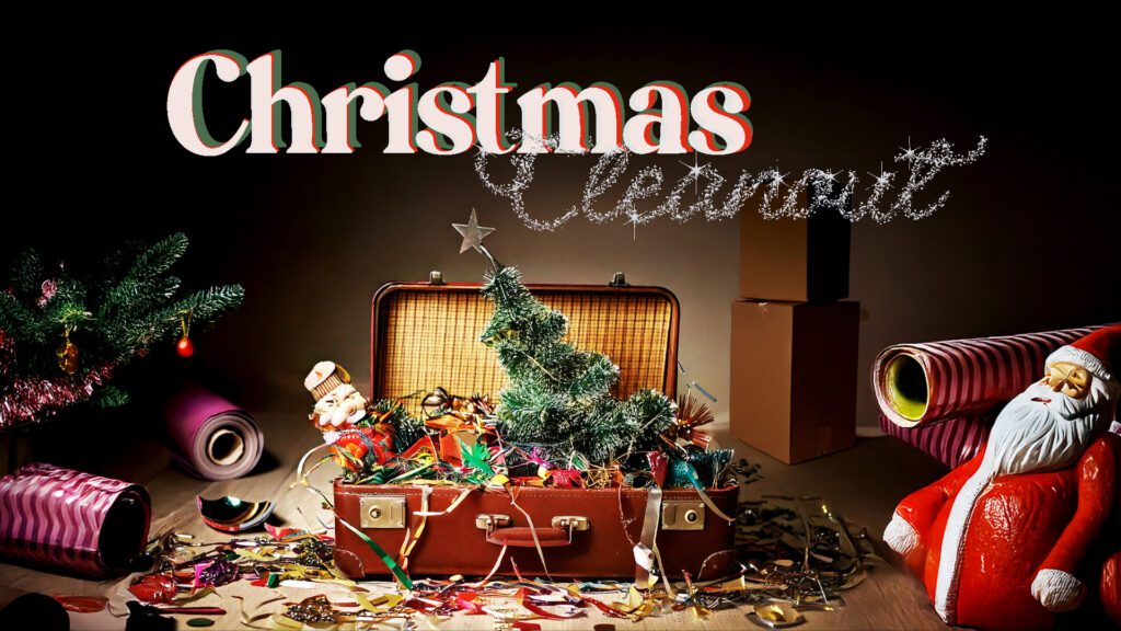 Vintage suitcase filled with Christmas decorations and a small tree.