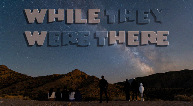People stargazing under a starry night with mountains in the background.
