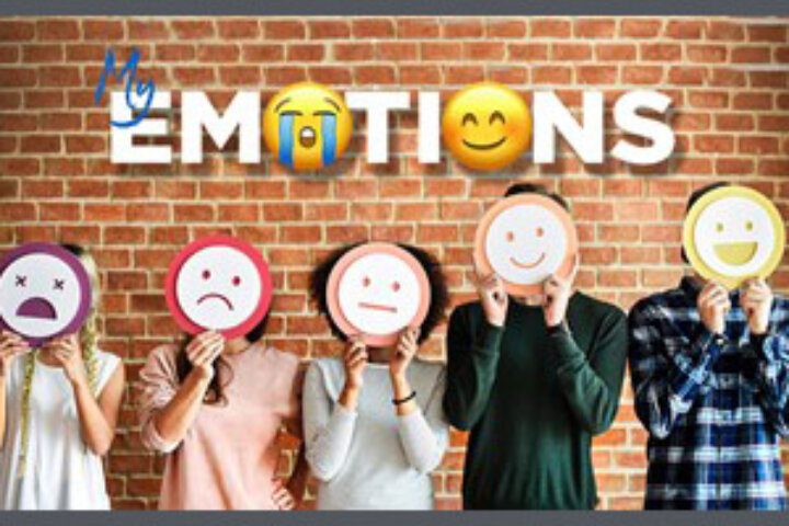 People holding emoji faces against brick wall
