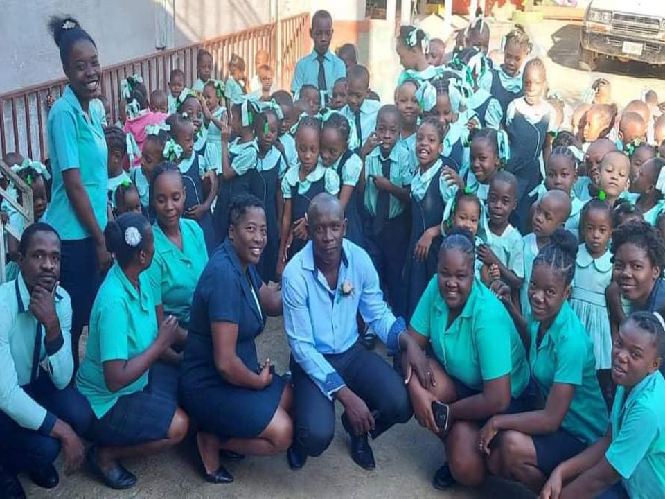 School children and teachers smiling outdoors