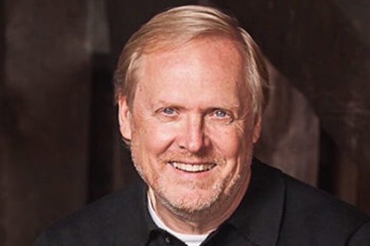 Man smiling with a dark background