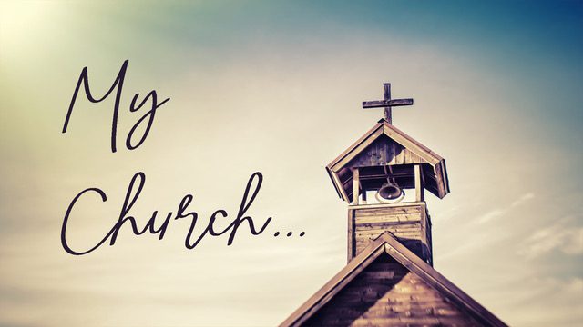 A rustic church steeple with a cross against a soft sky.
