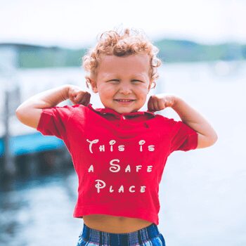 Young boy posing confidently at lakeside
