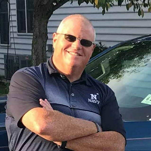 Person in navy shirt by car