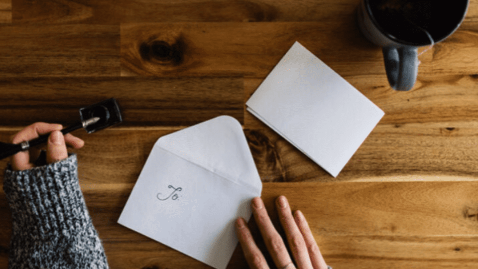 Person preparing a letter with envelope