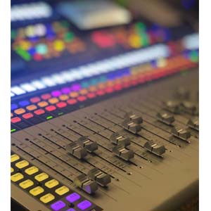 Close-up of an audio mixing console with colorful buttons and sliders.