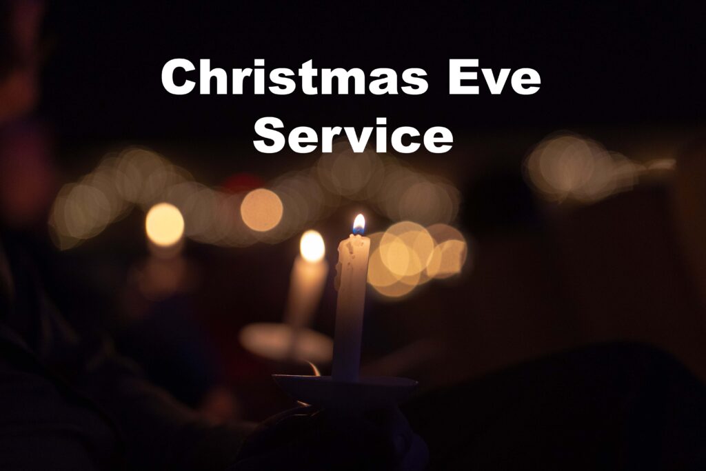 Hands holding lit candles during a Christmas Eve service.