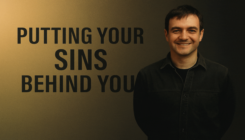 Man smiling beside a motivational quote on a wall.